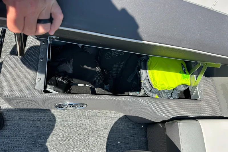 Slide: The Image of Open storage compartment on 2022 Godfrey SWEETWATER 2286 SFL boat, containing life jackets. - 14
