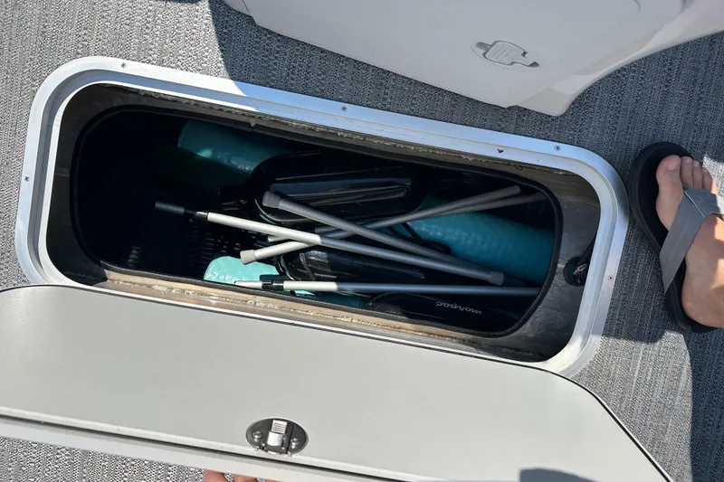 Slide: The Image of Storage compartment on 2022 Godfrey SWEETWATER 2286 SFL boat, containing paddles and equipment. - 17