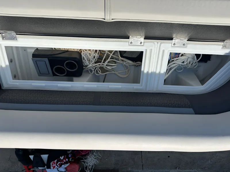 Slide: The Image of Storage compartment on 2022 Godfrey SWEETWATER 2286 SFL boat with ropes and cup holders. - 7
