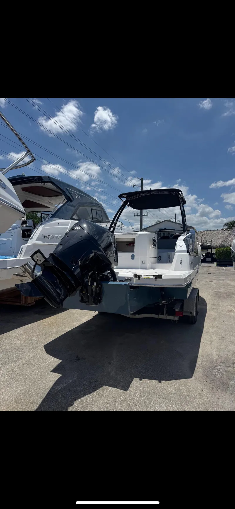 Slide: The Image of 2025 NX Boats NX270 with outboard motor, parked outdoors under a clear sky. - 3