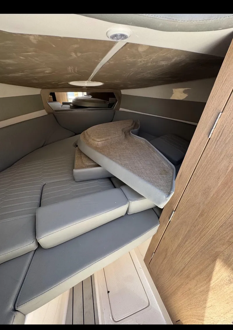 Slide: The Image of Interior cabin of 2025 NX Boats NX270 with cushioned seating and wooden accents. - 7