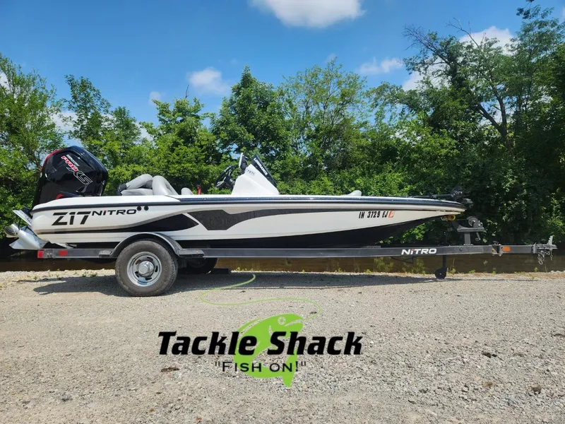 Slide: The Image of 2022 Nitro Z17 boat on trailer, parked outdoors with trees in background. - 1