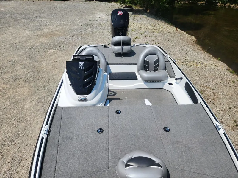 Slide: The Image of 2022 Nitro Z17 boat with gray seating and carpeted deck, parked near a riverbank. - 10