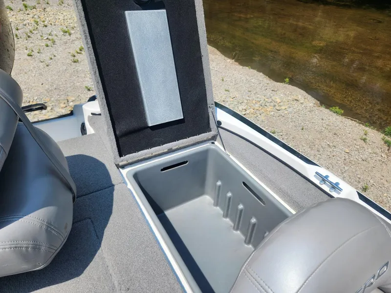 Slide: The Image of Open storage compartment in a 2022 Nitro Z17 boat, near a riverbank. - 14