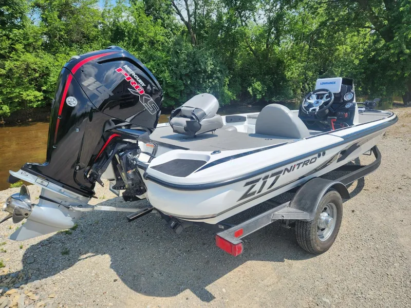 Slide: The Image of 2022 Nitro Z17 boat with Mercury Pro XS engine, parked on a trailer by a river. - 5