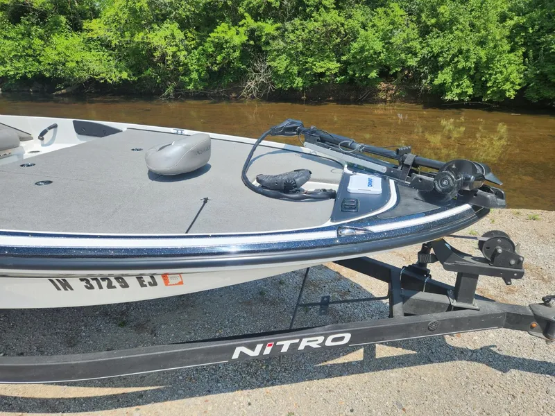 Slide: The Image of 2022 Nitro Z17 boat on trailer by riverbank, surrounded by lush greenery. - 6