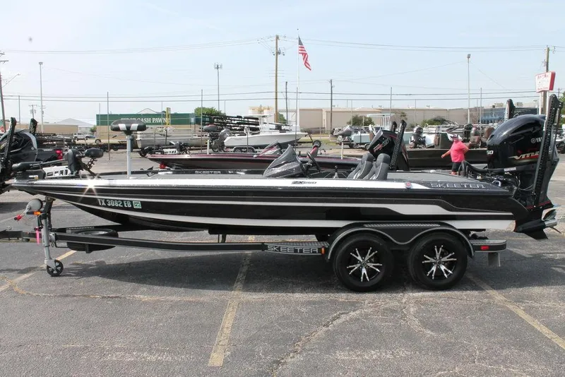 Slide: The Image of 2018 Skeeter ZX250 bass boat on trailer in parking lot, side view. - 2