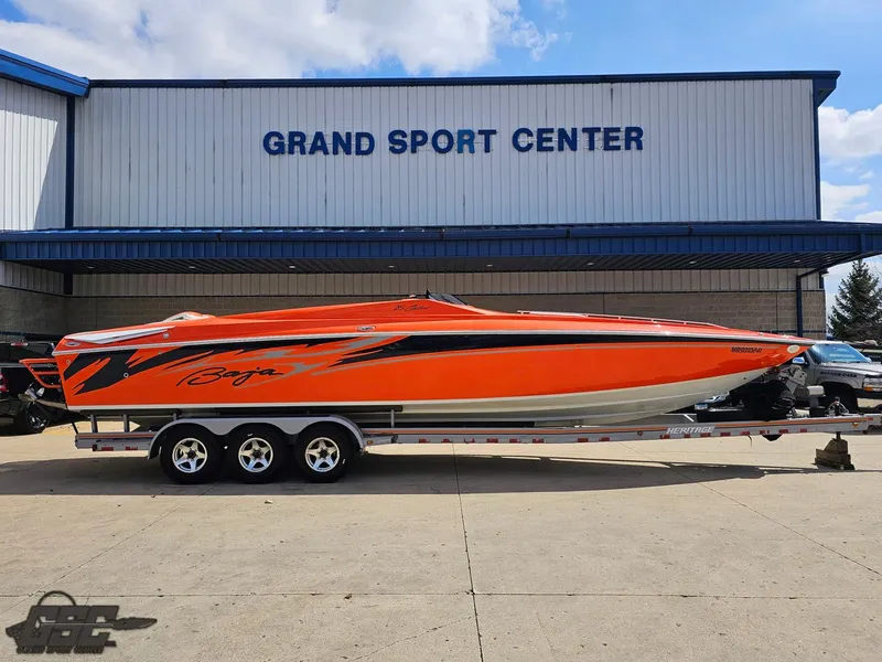 Slide: The Image of 2007 Baja 35 Outlaw boat in vibrant orange at Grand Sport Center. - 1