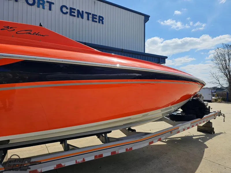 Slide: The Image of 2007 Baja 35 Outlaw boat on trailer at a port center, vibrant orange hull. - 10
