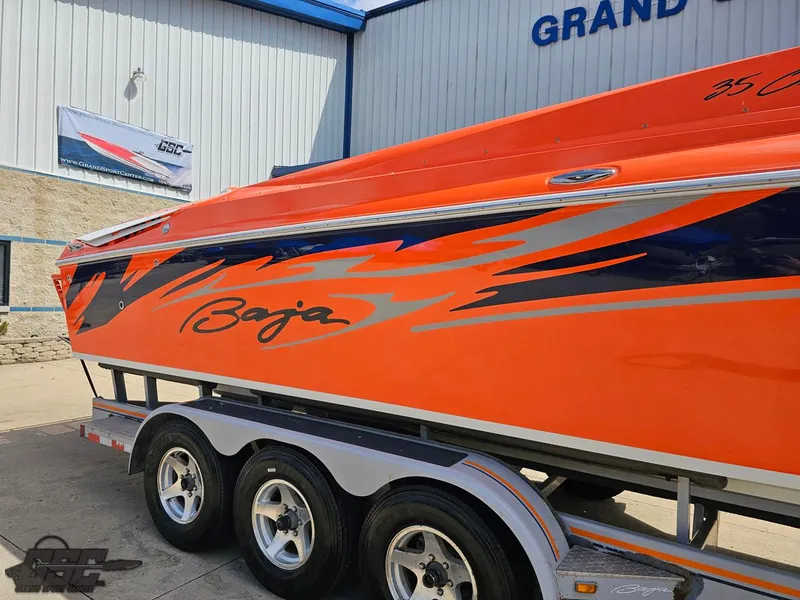 Slide: The Image of 2007 Baja 35 Outlaw boat with vibrant orange and blue design on a trailer. - 11
