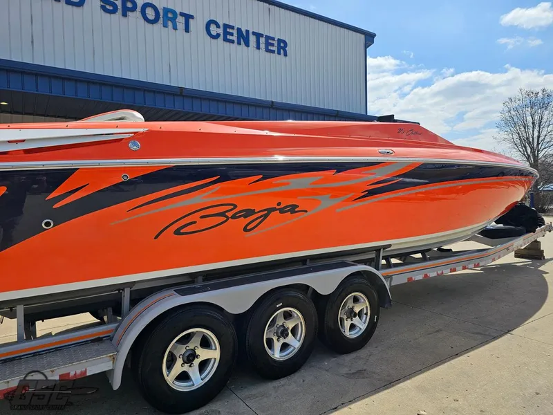 Slide: The Image of 2007 Baja 35 Outlaw speedboat with vibrant orange and black design on a trailer. - 13