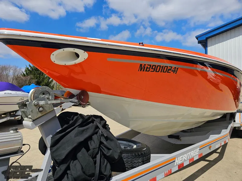 Slide: The Image of 2007 Baja 35 Outlaw boat on trailer, vibrant orange hull, clear sky background. - 17