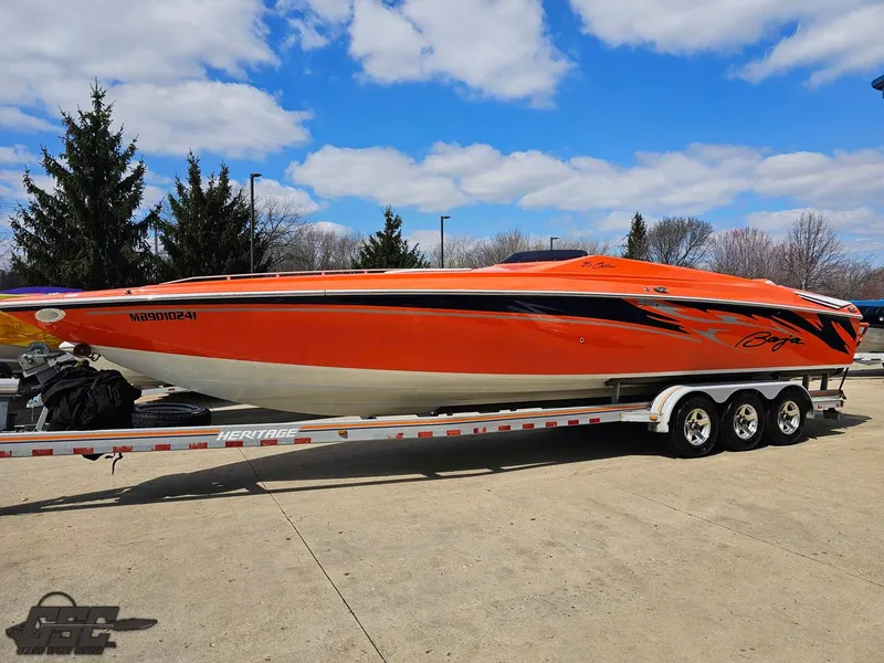 Slide: The Image of 2007 Baja 35 Outlaw speedboat in vibrant orange on a trailer, under a blue sky. - 18