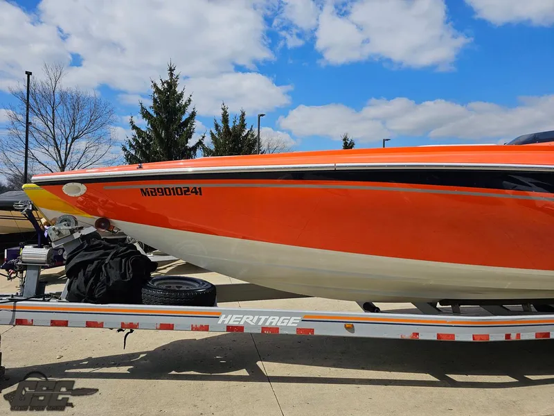 Slide: The Image of 2007 Baja 35 Outlaw boat on trailer, vibrant orange hull, clear sky background. - 19