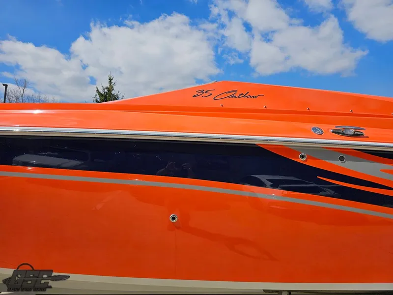 Slide: The Image of 2007 Baja 35 Outlaw boat with vibrant orange and blue design under a clear sky. - 22
