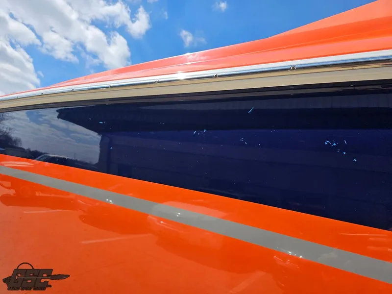 Slide: The Image of 2007 Baja 35 Outlaw boat with vibrant orange and blue exterior under a clear sky. - 24
