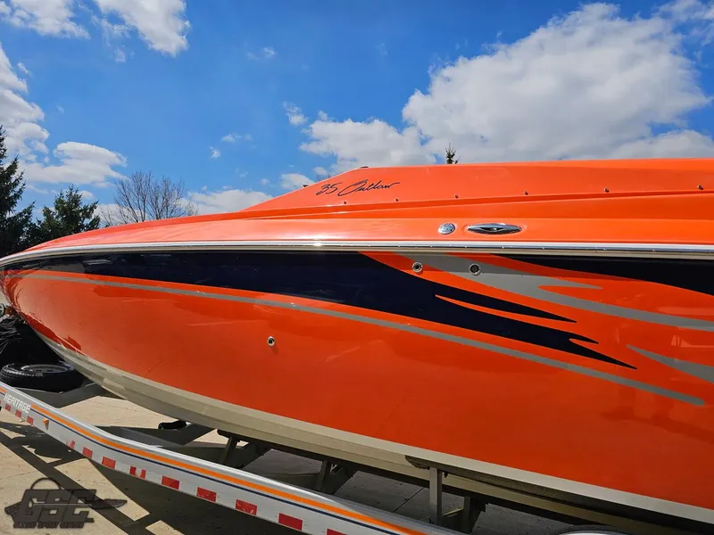 Slide: The Image of 2007 Baja 35 Outlaw boat with vibrant orange and blue design on a trailer. - 25