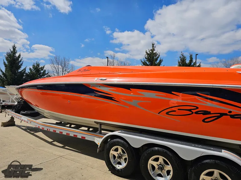 Slide: The Image of 2007 Baja 35 Outlaw speedboat with vibrant orange and black design on a trailer. - 26