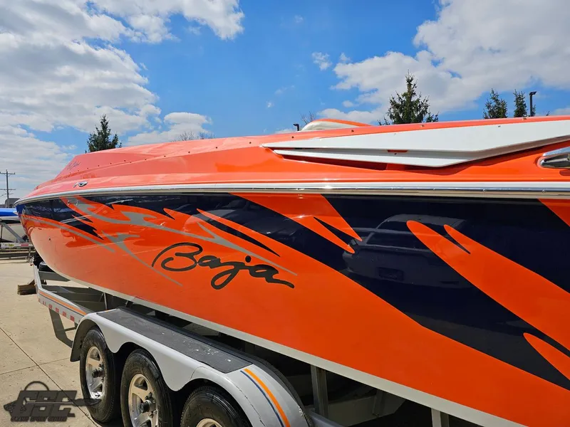 Slide: The Image of 2007 Baja 35 Outlaw boat with vibrant orange and blue design on a trailer. - 29