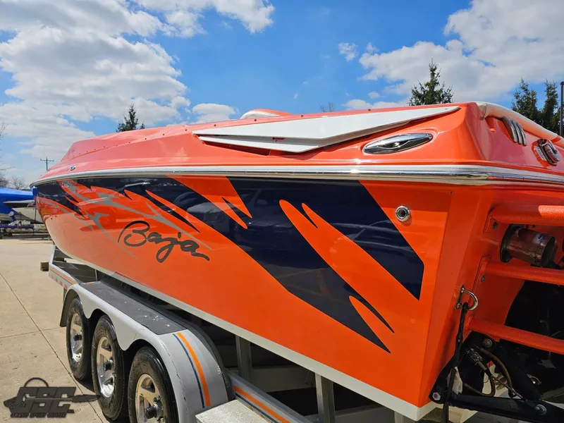 Slide: The Image of 2007 Baja 35 Outlaw boat with vibrant orange and blue design on trailer. - 30