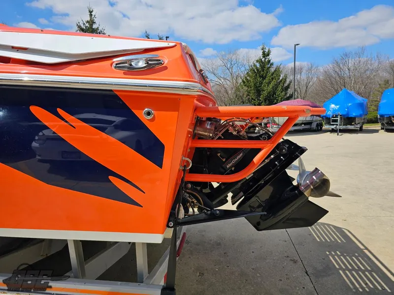 Slide: The Image of 2007 Baja 35 Outlaw boat with vibrant orange and blue design, parked outdoors. - 31