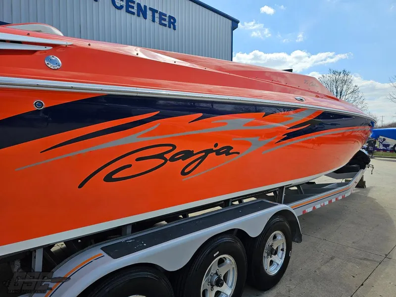 Slide: The Image of 2007 Baja 35 Outlaw boat with vibrant orange and blue design on a trailer. - 36