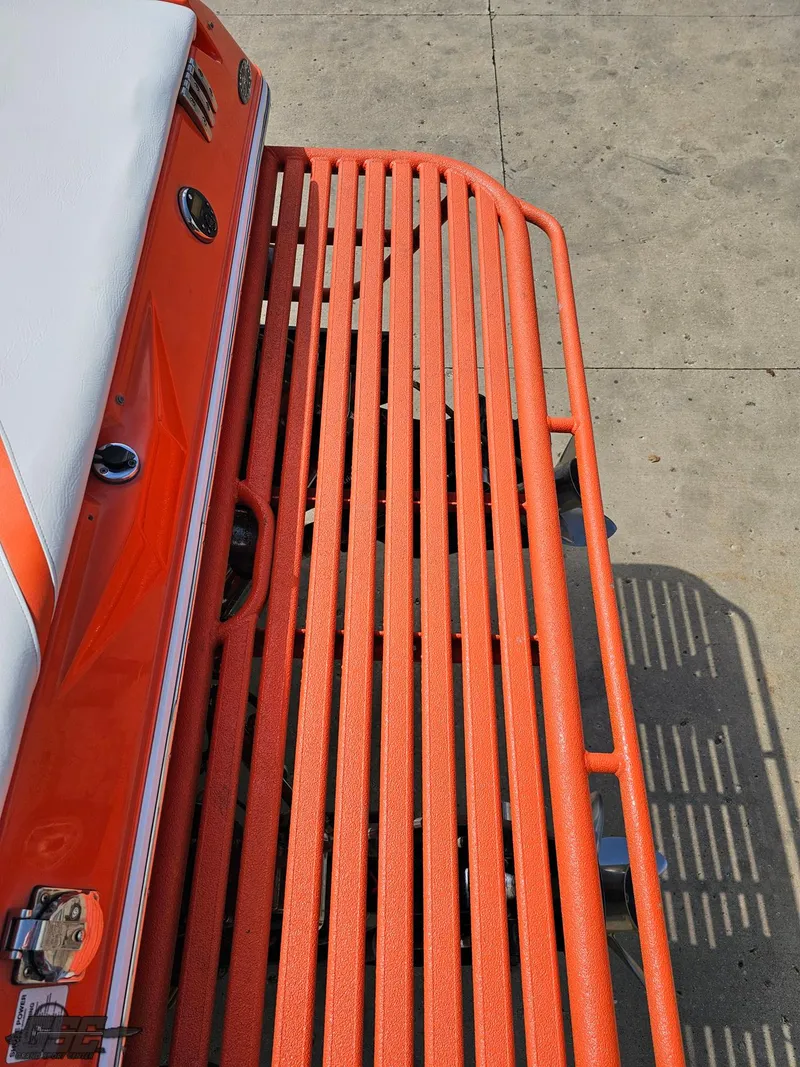 Slide: The Image of 2007 Baja 35 Outlaw boat with orange detailing and white seating on a concrete surface. - 42