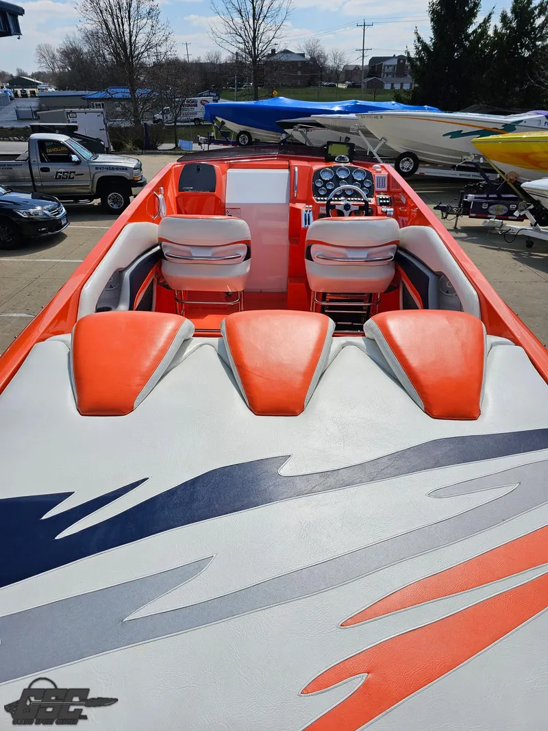 Slide: The Image of 2007 Baja 35 Outlaw boat with vibrant orange and white interior, docked outdoors. - 44