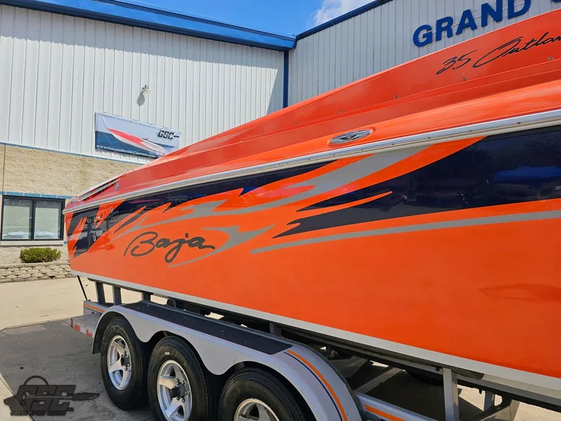 Slide: The Image of 2007 Baja 35 Outlaw boat with vibrant orange and blue design on a trailer. - 6