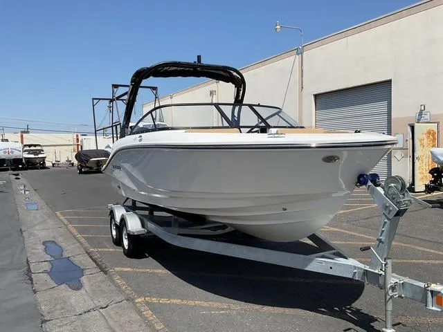 Slide: The Image of 2025 Bayliner V20i boat on trailer in industrial area. - 2