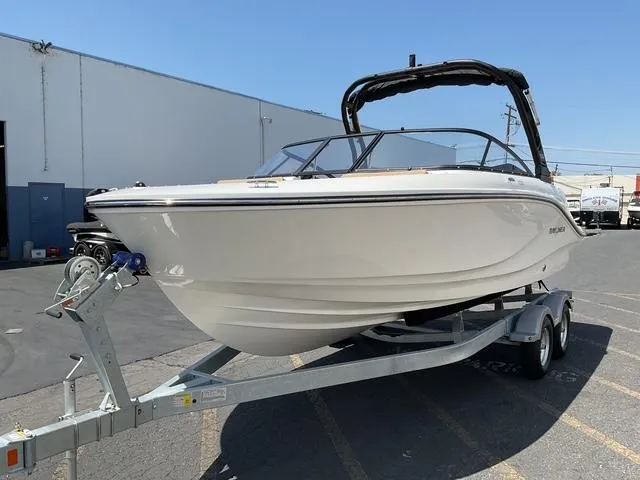 Slide: The Image of 2025 Bayliner V20i boat on trailer, parked outdoors under clear blue sky. - 3