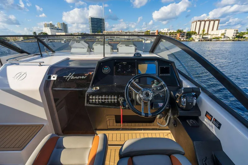 Slide: The Image of 2025 Hanover 377 Outboard boat cockpit with modern controls and waterfront city view. - 10