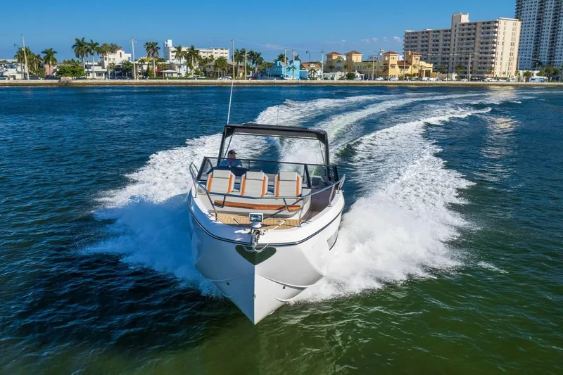 Slide: The Image of 2025 Hanover 377 Outboard cruising on water near city skyline. - 5