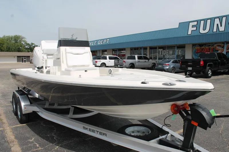 Slide: The Image of 2026 Skeeter SX221 boat on trailer outside dealership, showcasing sleek design and modern features. - 7