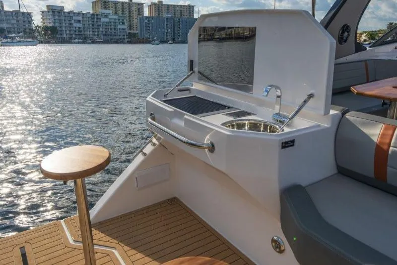 Slide: The Image of 2025 Hanover 377 Outboard boat with outdoor kitchen and scenic waterfront view. - 12