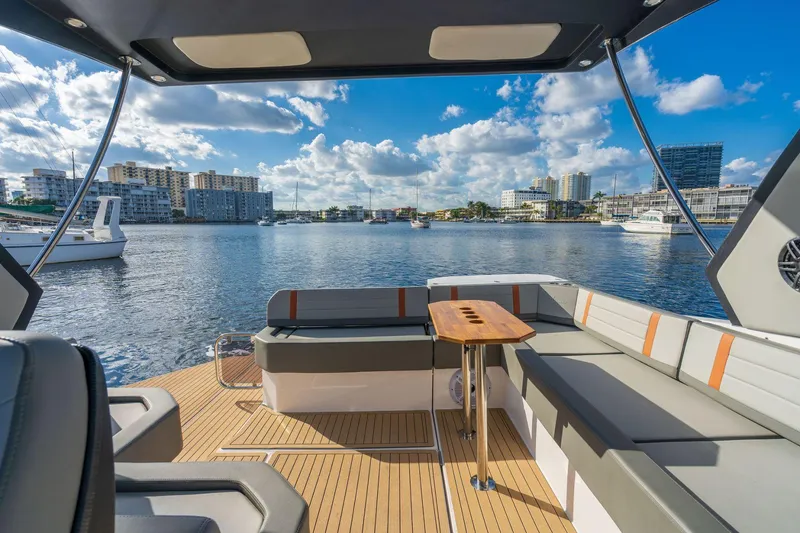 Slide: The Image of Luxury seating area on 2025 Hanover 377 Outboard boat, overlooking a scenic marina. - 8