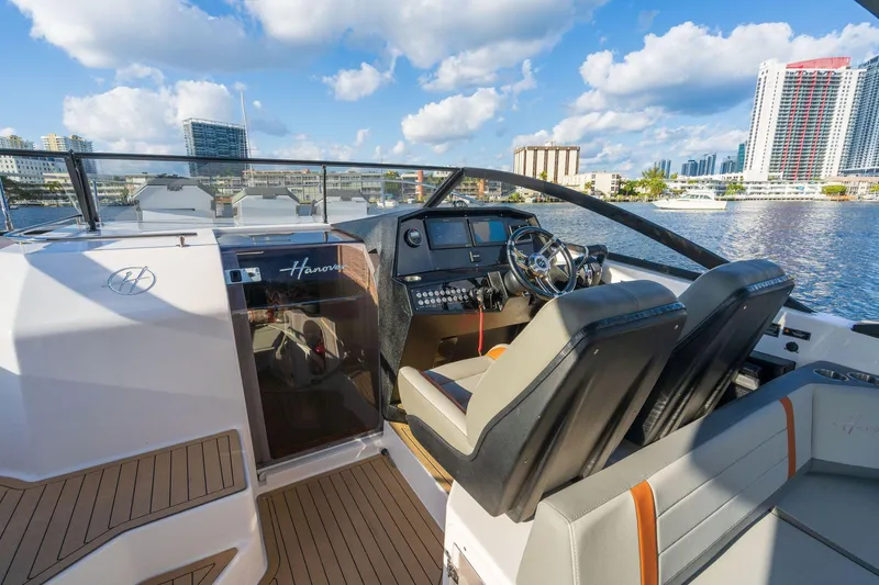 Slide: The Image of 2025 Hanover 377 Outboard boat interior with modern dashboard and waterfront city view. - 9