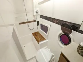 Slide: The Image of 2025 Hanover 375 Outboard boat bathroom with modern fixtures and porthole window. - 14