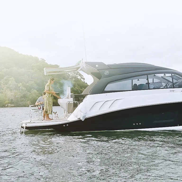 Slide: The Image of 2025 Hanover 355 Outboard boat on water with people enjoying a barbecue. - 2