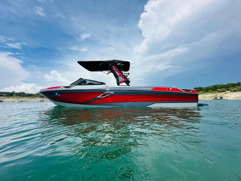 The Image of 2021 Centurion Ri265 boat on calm water under a partly cloudy sky. - 0