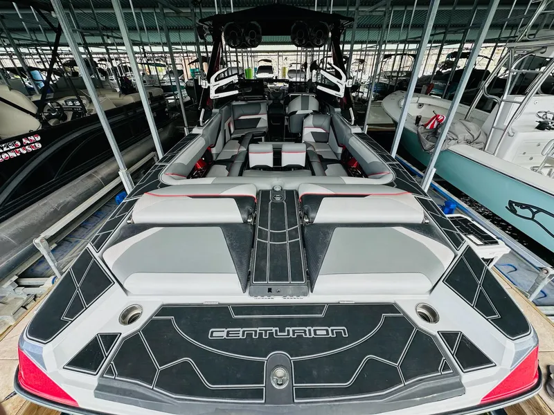 Slide: The Image of 2021 Centurion Ri265 boat interior with sleek seating and modern design in a marina. - 12