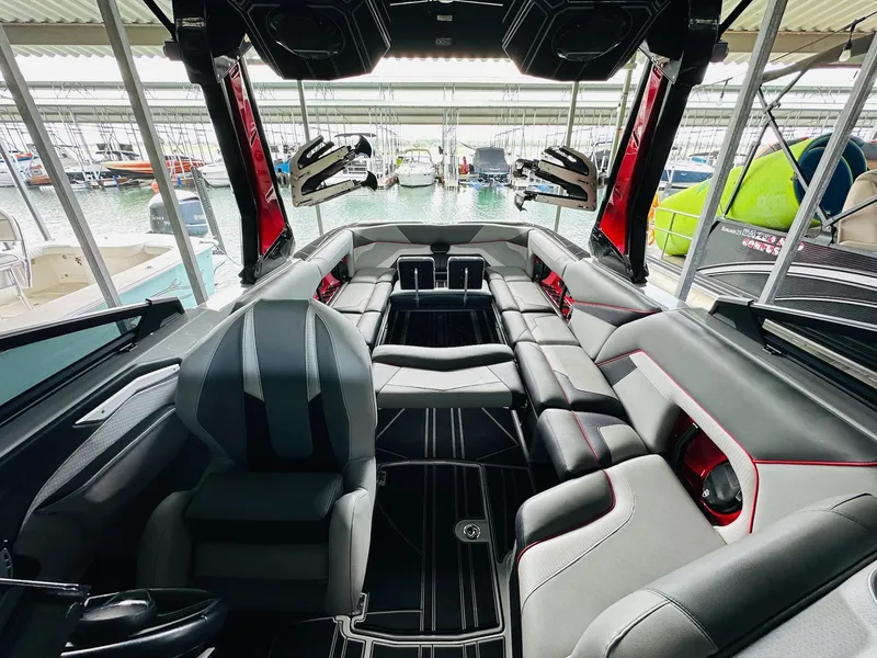 Slide: The Image of 2021 Centurion Ri265 boat interior with luxurious seating and modern design in a marina setting. - 15