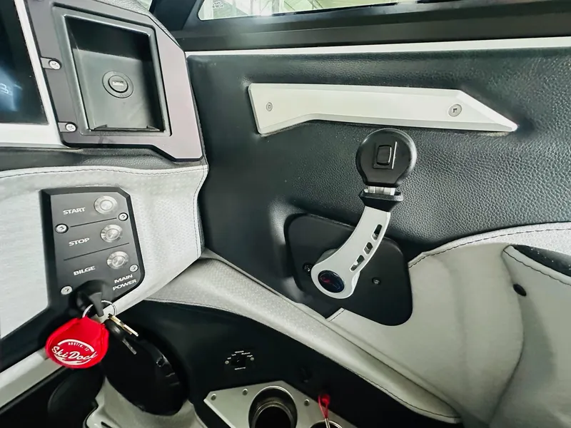 Slide: The Image of 2021 Centurion Ri265 boat interior controls and dashboard with start-stop buttons and key. - 17