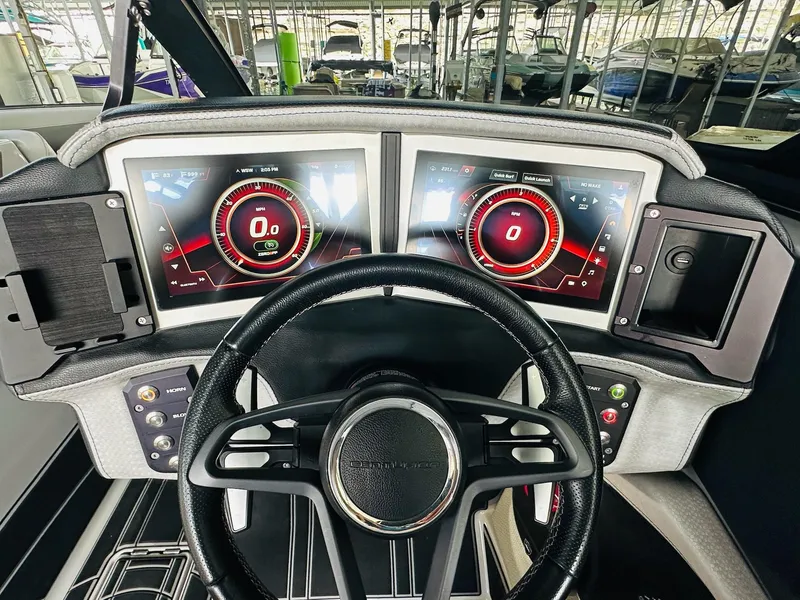 Slide: The Image of 2021 Centurion Ri265 dashboard with dual digital displays and steering wheel in a boat showroom. - 19