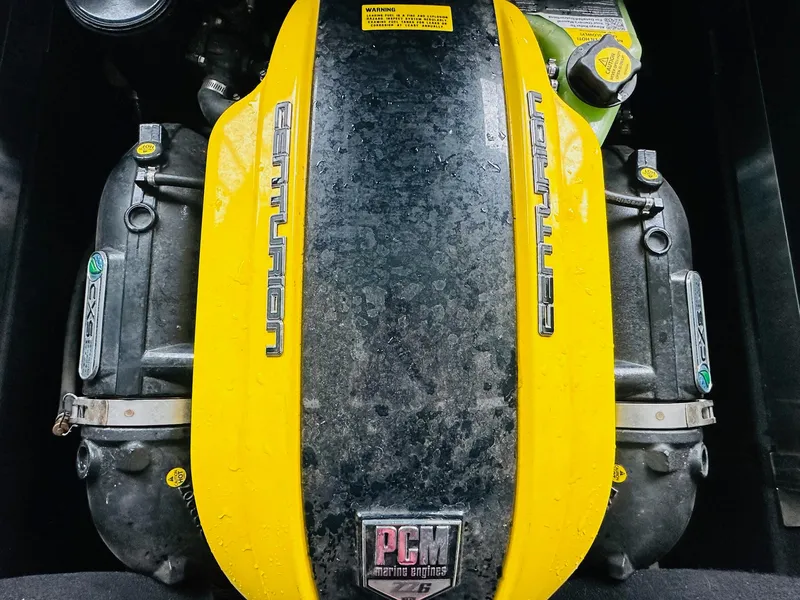 Slide: The Image of 2021 Centurion Ri265 engine with yellow cover, featuring PCM marine branding. - 22