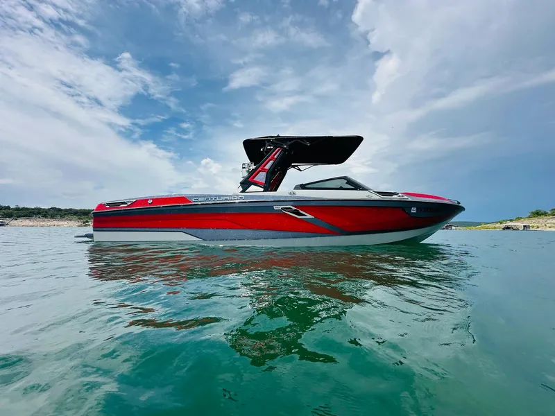 Slide: The Image of 2021 Centurion Ri265 boat on calm water under a partly cloudy sky. - 3