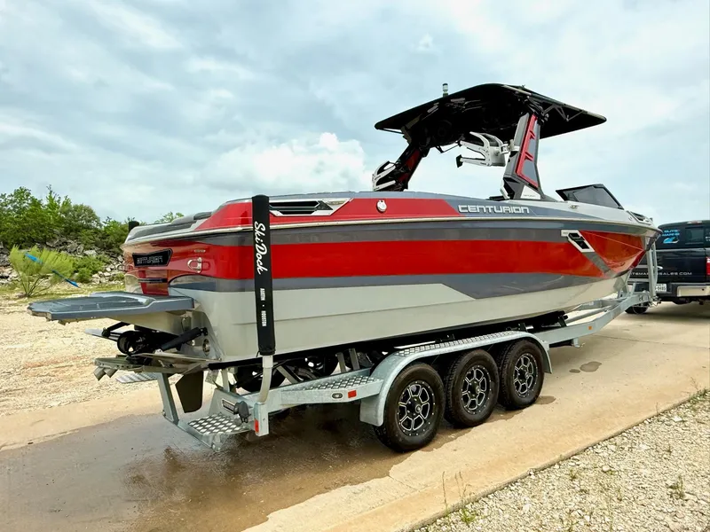 Slide: The Image of 2021 Centurion Ri265 boat on trailer, red and gray design, parked outdoors. - 6