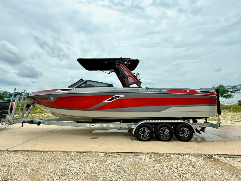 Slide: The Image of 2021 Centurion Ri265 boat on trailer, red and gray design, parked outdoors. - 7