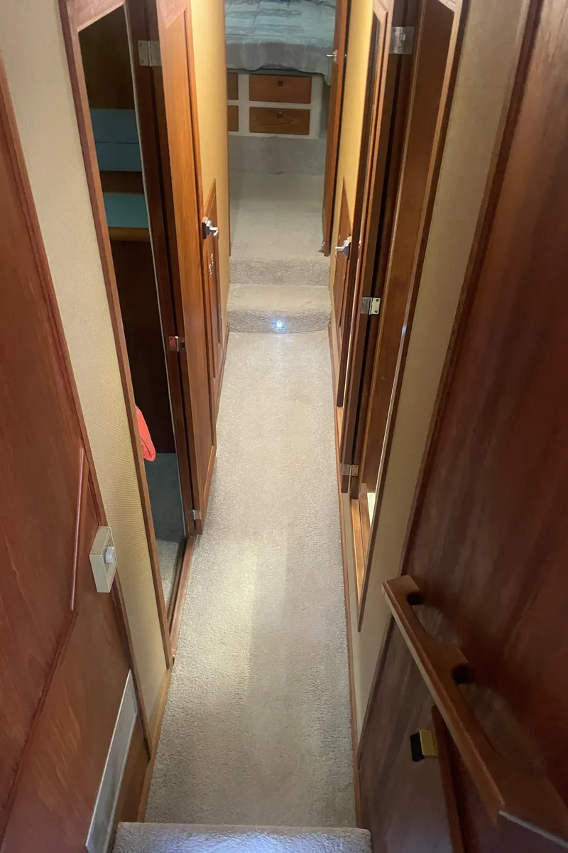 Slide: The Image of Interior hallway of a 1988 Bayliner 4588 yacht with wooden doors and carpeted floor. - 15