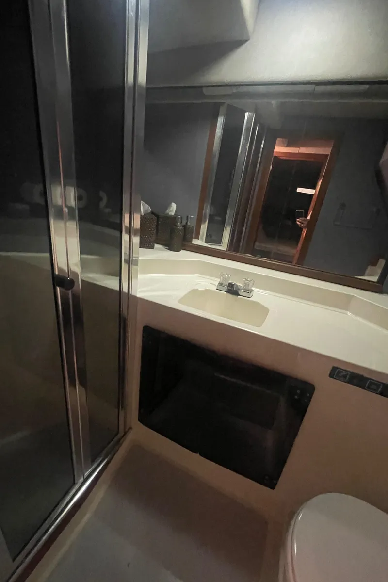 Slide: The Image of Bathroom interior of 1988 Bayliner 4588 yacht with sink, mirror, and shower. - 16